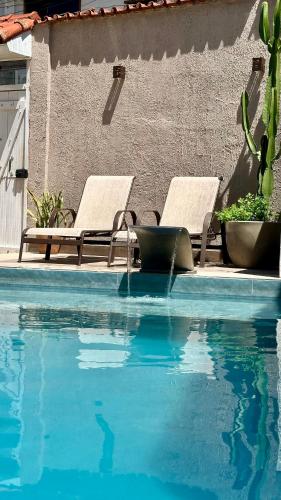 two lounge chairs sitting next to a swimming pool at Pousada Bonanza in Arraial do Cabo