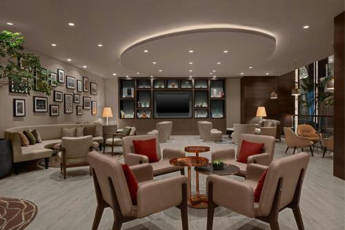 a lobby with a waiting room with chairs and a television at Le Meridien Istanbul Etiler in Istanbul