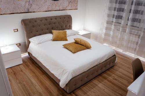 a bedroom with a large bed with two pillows on it at Mar House & Suites Guest House in Castellammare di Stabia