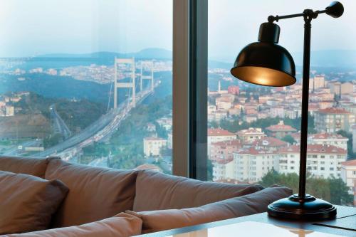 a lamp sitting on a table next to a couch at Le Meridien Istanbul Etiler in Istanbul