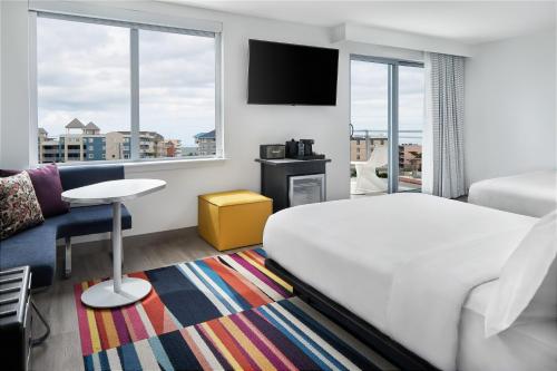 a hotel room with a bed and a couch at Aloft Ocean City in Ocean City