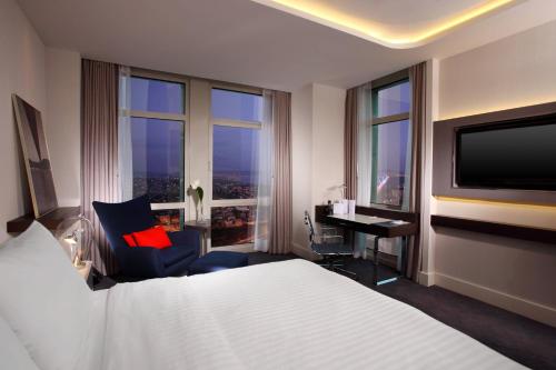a hotel room with a bed and a desk and a television at Le Meridien Istanbul Etiler in Istanbul
