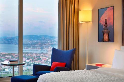 a hotel room with a bed and a chair and a window at Le Meridien Istanbul Etiler in Istanbul