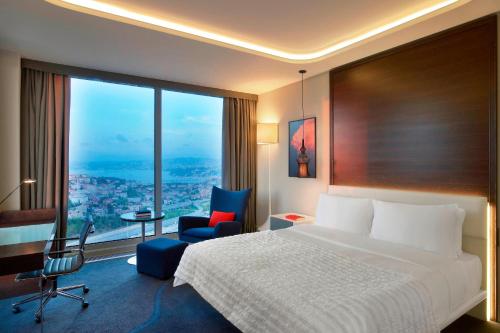 a hotel room with a bed and a chair and a window at Le Meridien Istanbul Etiler in Istanbul