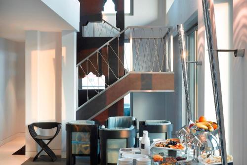 a dining room with a table and a staircase at Le Meridien Istanbul Etiler in Istanbul