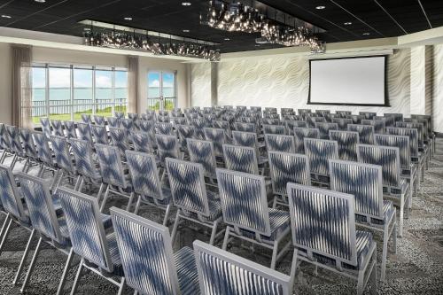 a conference room with chairs and a projection screen at Aloft Ocean City in Ocean City
