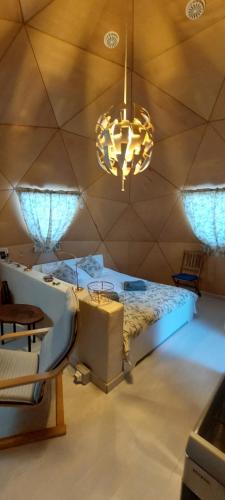 a bedroom with a large bed and a chandelier at vale das cupulas in Figueiró dos Vinhos
