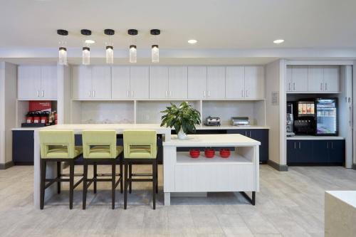 a kitchen with yellow chairs and a white counter top at TownePlace Suites by Marriott Hamilton in Hamilton