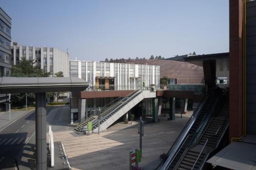 a building with an escalator in the middle of a city at Aloft Dongguan Songshan Lake in Dongguan