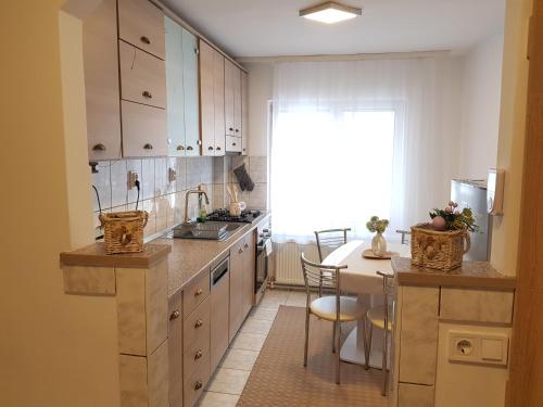 a kitchen with white cabinets and a table with chairs at Apartament Ana in Topliţa