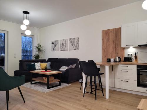 a kitchen and living room with a couch and a table at Apartament Chodzież blisko jeziora in Chodzież