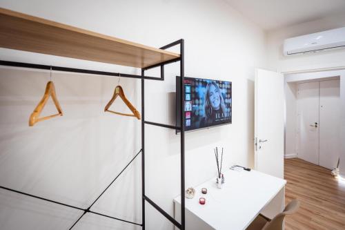 a room with a white table and a tv on the wall at Mar House & Suites Guest House in Castellammare di Stabia