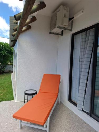 an orange bench on the side of a building at Sea La Vie - Holiday Home in Albion