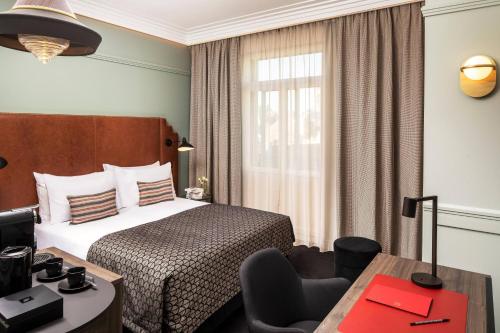 a hotel room with a bed and a desk at Maison Rouge Strasbourg Hotel & Spa, Autograph Collection in Strasbourg