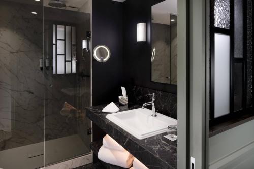 a bathroom with a sink and a shower at Maison Rouge Strasbourg Hotel & Spa, Autograph Collection in Strasbourg