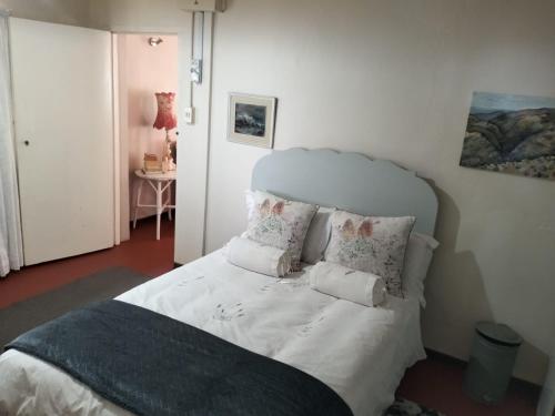 a bedroom with a bed with white sheets and pillows at Primula Cottage at Hillhouse in Hilton