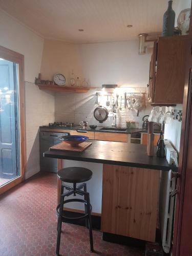 une cuisine avec un comptoir et un tabouret. dans l'établissement Maison avec jardin à louer au bord de la mer, à Argelès-sur-Mer