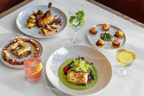 a white table topped with plates of food and drinks at W Austin in Austin