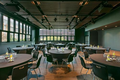 a restaurant with tables and chairs in a room with windows at W Austin in Austin