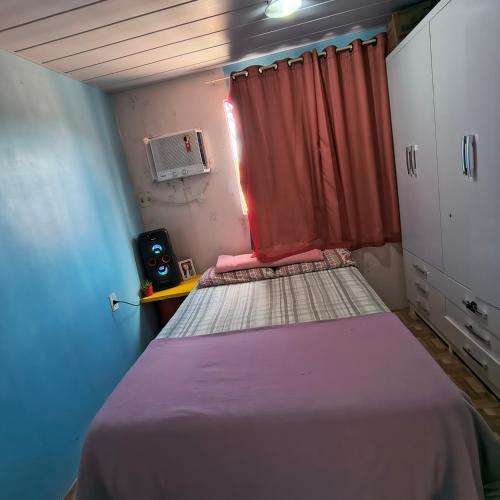 a small room with two beds and a window at Casa em Manaus in Manaus