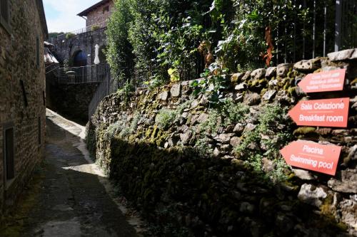 a stone wall with street signs on it at Agriturismo Montagna Verde Apella in Licciana Nardi