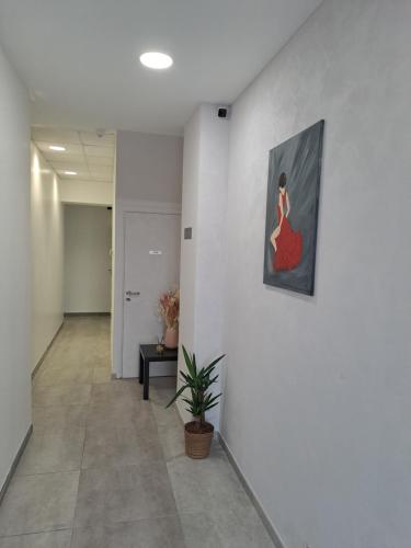 a hallway with a painting of a woman in a red dress at Be Zen ô Bizet Appartement moderne ultra confort jusqu'à 5 personnes in Le Bizet