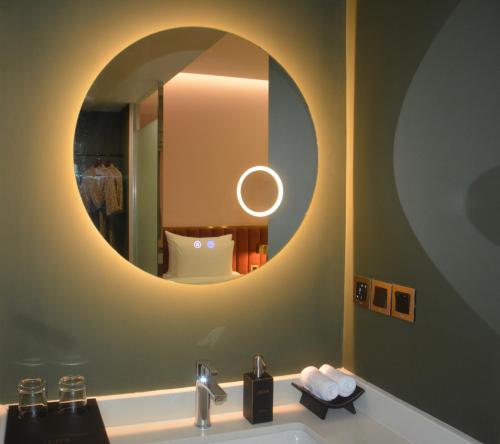 a bathroom with a sink and a mirror at DUO by CASEPIA Hotel in Phu Quoc
