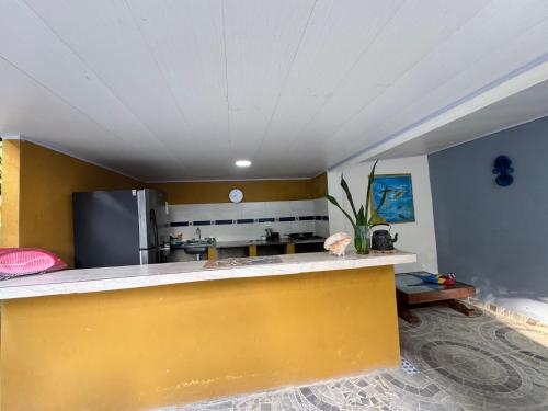 a kitchen with a yellow counter in a room at Casa Aventureros Isla Grande Colombia in Cartagena de Indias