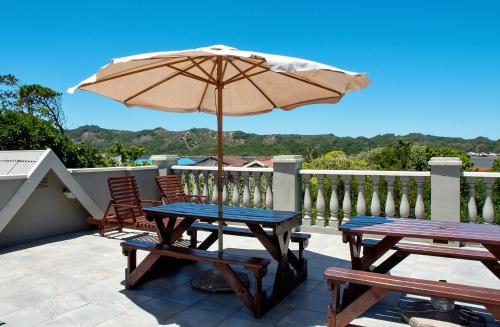 a patio with two tables and an umbrella at Avemore Island Home- full power back up-magical views in Sedgefield
