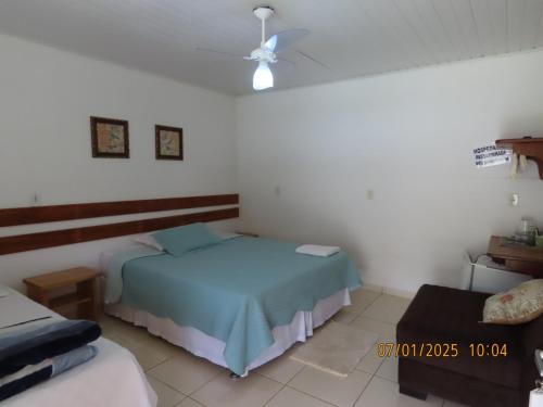 a bedroom with a blue bed and a couch at Passarinhada Hospedagem in Domingos Martins