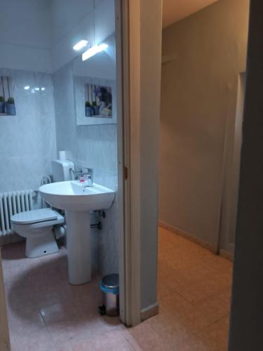 a bathroom with a white sink and a toilet at SWEET e SLEEP in Parma