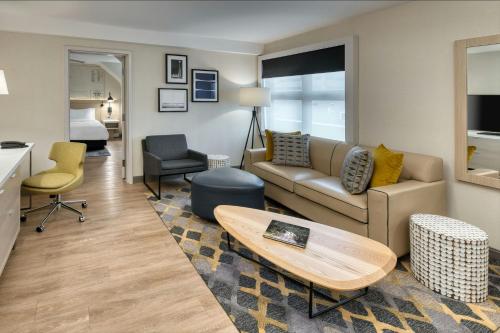 a living room with a couch and a table at The Insignia Hotel, Sarnia, a Tribute Portfolio Hotel in Sarnia