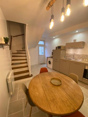 a kitchen with a wooden table and a wooden staircase at Cocon détente & Balnéo in Dieppe