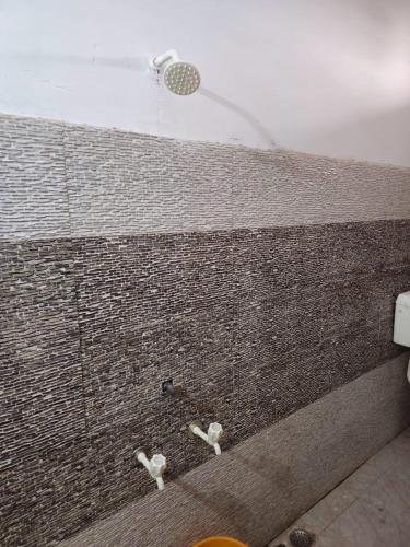 a shower with a shower head on a brick wall at Agrima palace in Rewa