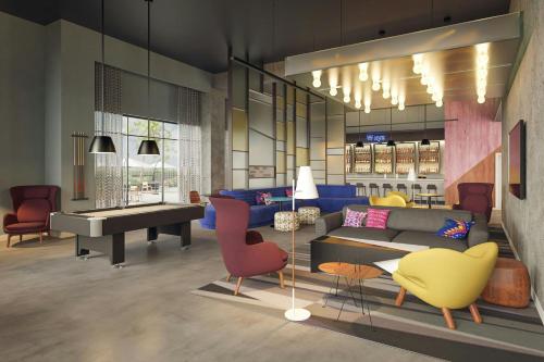 a living room with a couch and a piano at Aloft Santo Domingo Piantini in Santo Domingo