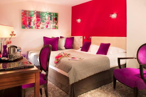 a hotel room with a bed with purple accents at Hotel Best Western Anjou Lafayette in Paris