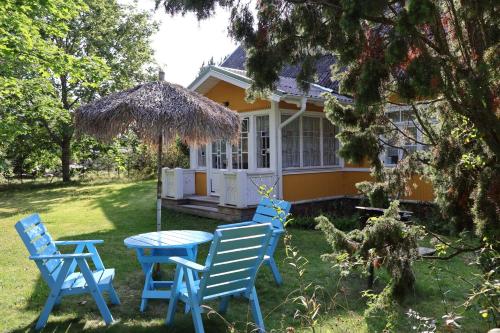 two blue chairs and a table in front of a house at Leesi Külalistemaja in Leesi