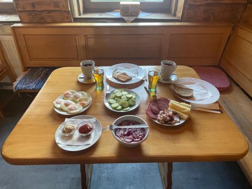 a wooden table with plates of food on it at Penzion Bistár in Habovka