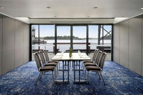 a dining room with a table and chairs and a large window at Pier One Sydney Harbour, Autograph Collection in Sydney