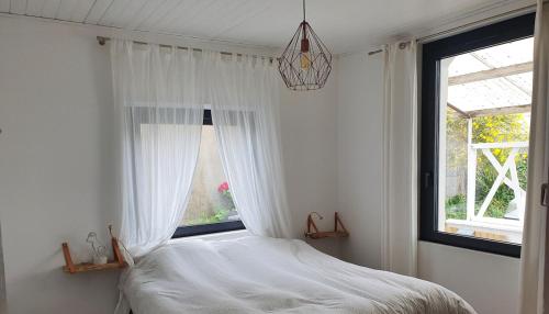 une chambre avec un lit et une fenêtre dans l'établissement charmante maisonnette a 400m de la plage, à Noirmoutier-en-l'lle