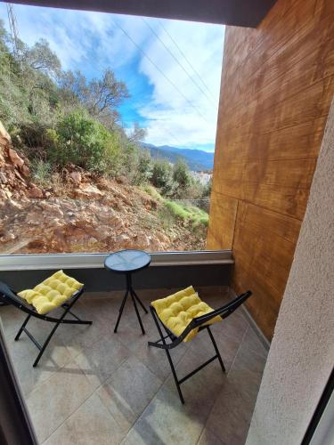 ブドヴァにあるStudioの椅子2脚とテーブル1台と窓のある部屋