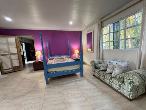 a bedroom with a blue bed and a couch at Casa Aventureros Isla Grande Colombia in Cartagena de Indias