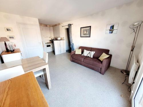 un salon avec un canapé et une table dans l'établissement Charmant T2 avec Balcon à Deux Pas de la Digue, Plein Ouest - Cuisine Équipée, Séjour Lumineux - FR-1-675-24, à Wimereux