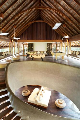 a large room with a table and benches in it at W Maldives in Fesdu Island
