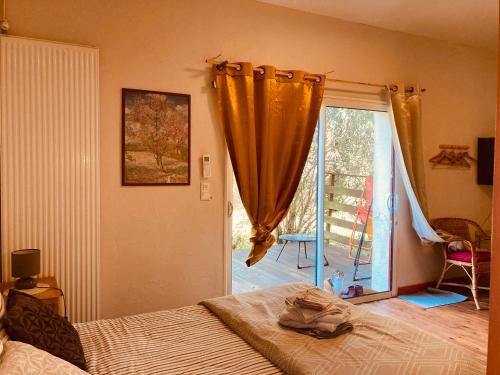 a bedroom with a bed and a sliding glass door at Métairie de Moutiques in Cazaubon