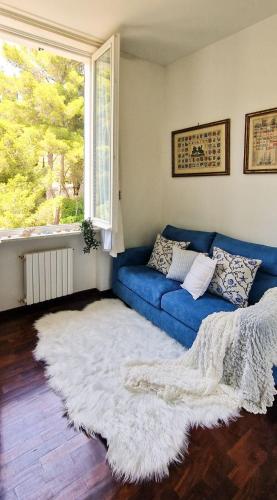 a blue couch in a living room with a white rug at TheKeyStudio, La stanza dei Sogni in Bordighera