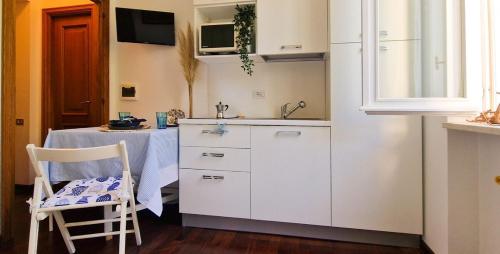 a kitchen with a sink and a table with a table at TheKeyStudio, La stanza dei Sogni in Bordighera