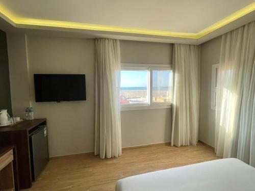 a hotel room with a bed and a television at Al Dora Resort All Inclusive Hotel in Hurghada