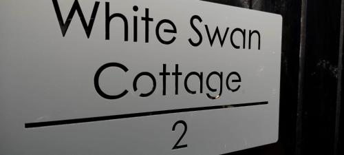 a white sign with the words white swan coffee at White Swan Cottage 2 in Hunmanby