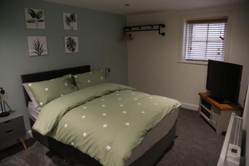 a bedroom with a bed and a flat screen tv at White Swan Cottage 2 in Hunmanby